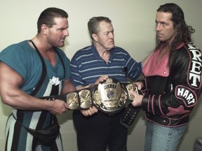 Wrestling patriarch Stu Hart with son Bret (right) and son-in law Davey Boy Smith (left). Davey Boy and Bret have tug of war with Bret's belt.