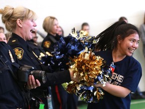 best photo - Saskatoon, SK - January 24, 2017 - Nikki Giroy, a student involved in the Functional Integrated Program at Bethlehem Catholic High School, shakes her pom poms with Constable Lisa Lafreniere during their POM routine for members of the Saskatoon Police Service in the main gym at Police Headquarters in Saskatoon on January 24, 2017. (Michelle Berg / Saskatoon StarPhoenix)