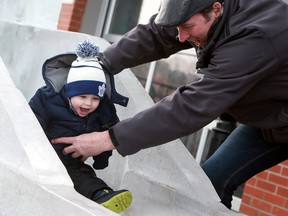 Cayde Musselman and his grandfather are all smiles as he slides down the ice slide during WinterShines at the Saskatoon Farmers' Market on Jan. 29, 2017.