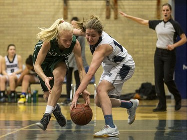 Holy Cross Crusaders' Emma Linsley (L) battles for the ball with Walter Murray Marauders' Emma Engen in high school girl's basketball action at Walter Murray Collegiate in Saskatoon, January 17, 2017.