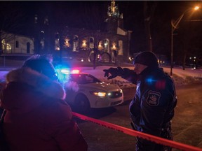 A Canadian police officer talks to a woman after a shooting in a mosque at the Québec City Islamic cultural center on Sainte-Foy Street in Quebec city on January 29, 2017. Two arrests have been made after five people were reportedly shot dead in an attack on a mosque in Québec City, Canada.