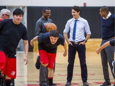 Canadian Prime Minister Justin Trudeau (middle) chats with Toronto Raptors head coach Dwane Casey (left) Raptors president and general manager Masai Ujiri, while they watch visiting students of La Loche Community School in Saskatchewan on the basketball court at the BioSteel Centre, where the Toronto Raptors practice, in Toronto, Ont. on Friday January 13, 2017.  Masai Ujiri, Toronto Raptors president and general manager, hosted a group of 10 kids, plus two teachers, from La Loche, Saskatchewan. Ernest Doroszuk/Toronto Sun/Postmedia Network