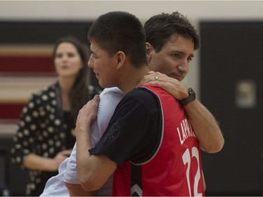Prime Minister Justin Trudeau hugs Braden Laprise following a practice for players from La Loche, Sask., held at the Toronto Raptors practice facility in Toronto on Friday, January 13, 2017.