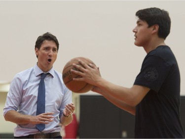 Prime Minister Justin Trudeau cheers on his team as players from La Loche, Sask., during a free throw drill during practice at the Toronto Raptors practice facility in Toronto on Friday, January 13, 2017.