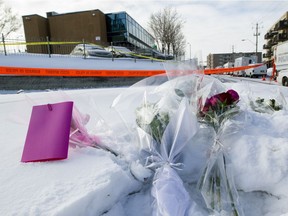 Bouquets lay in the snow close to the entrance of the Centre Culturel Islamique de Québec (background) in Quebec City on Jan. 30, 2017, the morning after six people were fatally shot at the mosque.