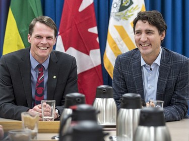 Prime Minister Justin Trudeau (R) speaks with Saskatoon Mayor Charlie Clark and city councillors at City Hall in Saskatoon, January 25, 2017.