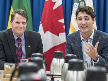 Prime Minister Justin Trudeau (R) speaks with Saskatoon Mayor Charlie Clark and city councillors at City Hall in Saskatoon, January 25, 2017.