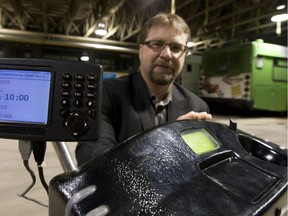 Saskatoon Transit special project co-ordinator Russell Dixon poses with the electronic fare boxes for buses in this December 2009 photo. (GREG PENDER/The StarPhoenix)