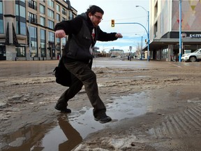 Commuters had to leap over muddy slush puddles as they crossed the streets downtown Saskatoon during the warm winter weather on January 18, 2017.