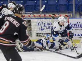 Saskatoon Blades goalie Logan Flodell dives behind defense Bryton Sayers to make a save against the Calgary Hitman during the first period of WHL action in Saskatoon, SK on Tuesday, January 10, 2017.