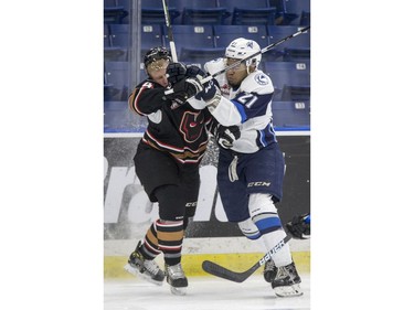 Saskatoon Blades forward Lukus MacKenzie collides with Calgary Hitmen defense Micheal Zipp during the first period of WHL action in Saskatoon, January 10, 2017.