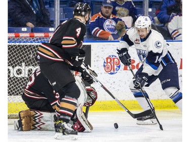 Saskatoon Blades forward Jesse Shynkaruk attempts to clip at a rebound in front of the Calgary Hitmen net during third period WHL action in Saskatoon, January 10, 2017.