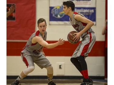 Bedford Road RedHawks guard Quinten Reichel (L) passes the ball to forward Umar Ali as they take on the  Dr. Martin Leboldus Suns during first quarter action of the opening game of the Bedford Road Invitational Tournament (BRIT) at Bedford Road Collegiate in Saskatoon, January 12, 2017.