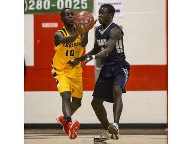 Dr. Martin Leboldus Suns guard Moses Onion passes the ball despite coverage from St. Francis Xavier Rams guard William Monga during their game in the Bedford Road Invitational Tournament (BRIT) at Bedford Road Collegiate in Saskatoon, January 13, 2017.