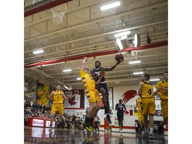 St. Francis Xavier Rams guard Geoffrey James goes in for a layup as Dr. Martin Leboldus Suns forward Marcus Roflik attempts to block him during their game in the Bedford Road Invitational Tournament (BRIT) at Bedford Road Collegiate in Saskatoon, January 13, 2017.