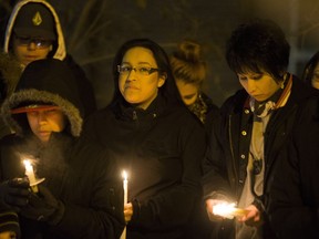 A group of people, including 21-year-old Crystal Kishayinew, sister of Rudy Kishayinew stands outside the Saskatoon Tribal Council's SHARP needle exchange honour and remember Rudy Kishayinew, who's body was found outside St. Pauls's hospital on Jan. 1 in Saskatoon, Sask. on Friday, Jan.13, 2017.