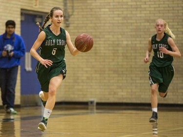 Holy Cross Crusaders' Katriana Philipenko (L) moves the ball against the Walter Murray Marauders  in high school girl's basketball action at Walter Murray Collegiate in Saskatoon, January 17, 2017.