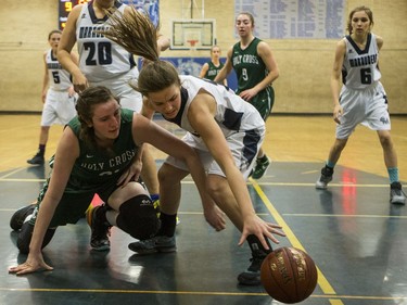 Holy Cross Crusaders' Kyla Shand (L) battles for a loose ball with Walter Murray Marauders Kami Hills in high school girl's basketball action at Walter Murray Collegiate in Saskatoon, January 17, 2017.