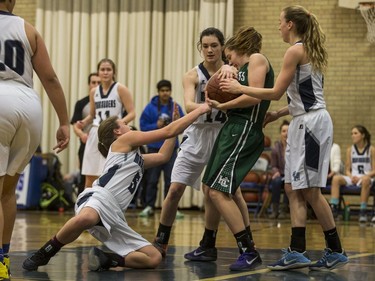 Holy Cross Crusaders' Regan Wilson battles for the ball against the Walter Murray Marauders  in high school girl's basketball action at Walter Murray Collegiate in Saskatoon, January 17, 2017.