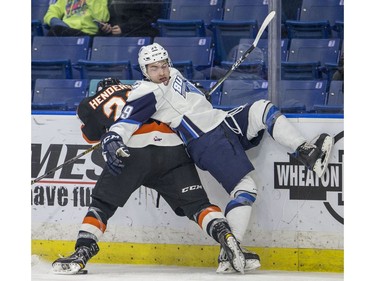 Saskatoon Blades forward Caleb Fantillo loses his feet in the corner against Medicine Hat Tigers defence Jordan Henderson during first period WHL action in Saskatoon, January 18, 2017.