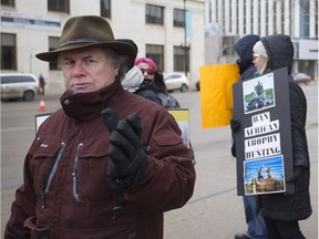 Michael Donovan, who is a part of an organization that protests against trophy hunting in Africa, stands outside the Hilton hotel in downtown Saskatoon to raise awareness on the practice of hunting during a trade show held at the hotel in Saskatoon, Sask. on Jan. 21, 2017.