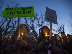 People gather for a solidarity vigil for the victims on the attack on the mosque in Quebec City and to protest President Donald Trump's travel ban at Saskatoon city hall in Saskatoon, Sask on Tuesday, Jan. 31, 2017.