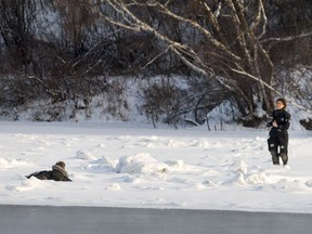 Saskatoon Firefighters and Saskatoon Police respond to a man walking on the ice as he breaks though the ice on the South Saskatchewan river between the University and Broadway Bridge in Saskatoon, SK on Thursday, January 5, 2017. The man was able to get out and was transported to hospital.