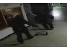 Surveillance footage shows two people dressed all in dark clothing stealing an ATM. (Saskatoon Police Service)