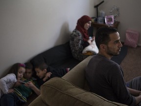 Parents Hicham and Ola Al Jneid sit in their living room with children (L to R) Amna, Hachim, Diaa and Aya(baby) who all recently came to Canada after taking governmental refugee status from their home country Syria in Saskatoon, SK on Saturday, February 18, 2017. (Saskatoon StarPhoenix/Kayle Neis)