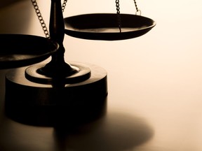 Scales of justice with back-light on wood table. Four cases in Saskatchewan have been thrown out due to delays following a recent Supreme Court of Canada Ruling.