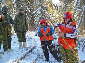 Vanessa Searson and Tammy Cook-Searson, members of the La Ronge Ranger Patrol, teach members of the Canadian Armed Forces how to make a rabbit snare.