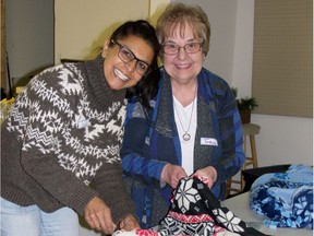 Cecilia Rajanayagam  and Teresa Field demonstrate how to tie fringe knots on the no-sew fleece blankets being gifted to refugees in Manitoba. Photo by Darlene Polachic