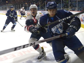 Saskatoon's Jantzen Leslie and Regina's Robbie Holmes go into the corner Tuesday night.