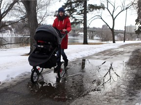 Elvira Goncharov pushes her stroller through a puddle during a walk along the meewasin trail in Saskatoon on March 15, 2017.