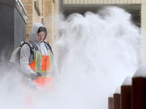 Workers clear the sidewalks in downtown Saskatoon after a heavy snowfall on March 5, 2017. (Michelle Berg / Saskatoon StarPhoenix)