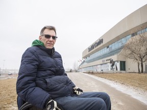 Paul Gustafson, who needs to use wheelchair accessible points of buildings, poses in front of the SaskTel Centre in Saskatoon, Sask. on Wednesday, Feb. 22, 2017. He says it's "very difficult" to attend a show at SaskTel Centre with his family due to restrictions on accessible ticket holders.