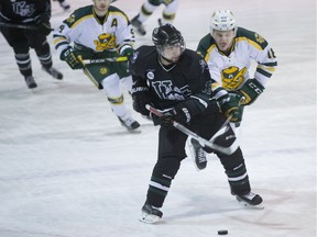 Huskies forward Kohl Bauml fights for the puck against Alberta forward Tyson Baillie at Rutherford Rink.