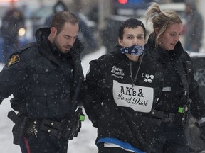 Saskatoon Police take William Roderick Gunn into custody after a car crashed into a garage, ending a police chase involving a stolen car containing four people. A shotgun was seized from the car after it crashed on Saturday, March 21, 2015. (LIAM RICHARDS/THE STAR PHOENIX)