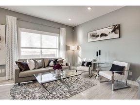 The decor of North Ridge Development's new show home at 105 Cowan Crescent in Lake Vista is fresh and contemporary. The interior features a popular grey and white colour palette, complemented by rustic-style whitewashed wide plank laminate flooring. Large windows overlooking Kinsmen Park invite an abundance of natural light into the room. © 2016 Scott Prokop Photography