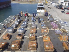 U.S. Customs and Border Patrol officers alongside Coast Guard personnel prepare to offload cocaine from the Coast Guard Cutter James, Tuesday, March 28, 2016, at Port Everglades in Fort Lauderdale, Fla.  The drugs were seized along Central and South America by the U.S. Coast Guard and the HMCS Saskatoon, which joined the operation in February.  (Joe Cavaretta/South Florida Sun-Sentinel via AP)
