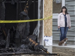 Suzanna D'Aprile, who was alerted to blaze at the home adjacent to hers by a passerby in middle of night, stands for a photograph with her dog Marty outside her home in Saskatoon, SK on Friday, April 7, 2017.