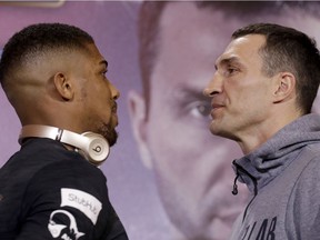 British boxer Anthony Joshua, left, and Ukrainian boxer Wladimir Klitschko pose head-to-head for the media at the end of a press conference at Sky studios in west London, Thursday, April 27, 2017. They are due to fight for the IBF heavyweight world title on Saturday at Wembley stadium in London.