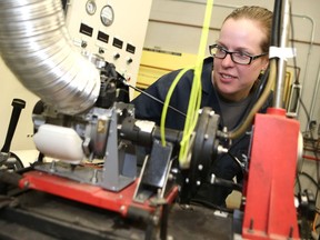 CAD/CAM Engineering Technology student Rebecca O'Shea takes a look at an engine similar to the one used in their ultra-fuel-efficient vehicle, which gets its world debut on April 27 in Detroit at the Shell Eco-Marathon. This is the first time Saskatchewan Polytechnic has ever competed in the marathon. (Michelle Berg / Saskatoon StarPhoenix)