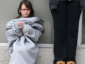 Daireen Dennis, 5, bundles up in her mom's jacket while waiting for a bus downtown Saskatoon on April 26, 2017. (Michelle Berg / Saskatoon StarPhoenix)