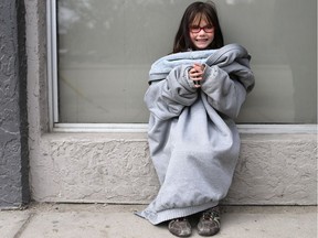 Daireen Dennis, age five, was bundled up in her mom's jacket while waiting for a bus in downtown Saskatoon on April 26, 2017. (Michelle Berg / Saskatoon StarPhoenix)