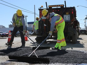 City of Saskatoon workers fill a pothole on the corner of First Avenue North and King Street in Saskatoon on April 5, 2017. Street sweeping and pot hole repairs have started early this year thanks to warm temperatures which dried up the roads. City-wide street sweeping will begin in May and citizens can report potholes online at saskatoon.ca/betterroads to help prioritize repairs.