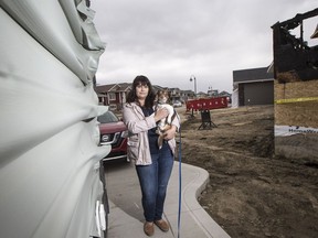 Suzanna D'Aprile, who was alerted to blaze at the home adjacent to hers by passerby in middle of night, stands for a photograph with her dog Marty outside her home in Saskatoon, SK on Friday, April 7, 2017.