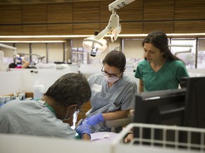 (L to R) Dr. Mohan Teekasingh, Melissa Janswick and Larqesa Janswick work on a patient during a free dental clinic at the University of Saskatchewan on April 8.