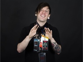 Vince Geiger holds up various festival passes he has collected during his years as a promoter during a studio shoot for Bridges in Saskatoon, SK on Saturday, April 15, 2017.