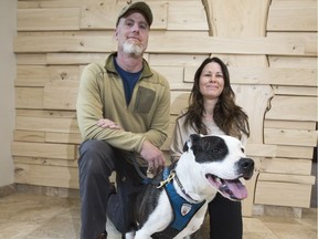 Marc Lapointe, left, his service dog Sticker and Colleen Dell stand for a photograph following a funding announcement to improve health care for patients in Saskatchewan, at the Gordon Oaks Red Bear Student Centre on the University of Saskatchewan campus.
